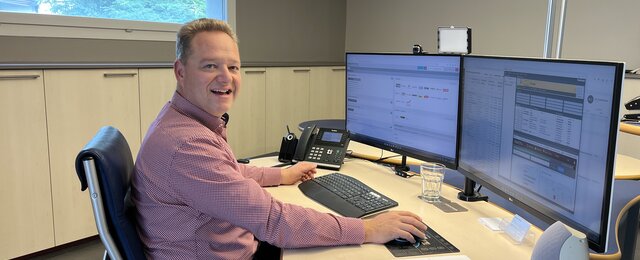 Bauleiter im Büro arbeitet mit zwei Bildschirmen an einer digitalen Bauzeitenplan Software für Terminplanung und Baukoordination.