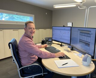 Bauleiter im Büro arbeitet mit zwei Bildschirmen an einer digitalen Bauzeitenplan Software für Terminplanung und Baukoordination.