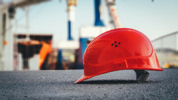 Roter Bauhelm auf der Baustelle als Symbol für Bauzeitenplan, Terminplanung und Bauablaufkoordination durch den Bauleiter